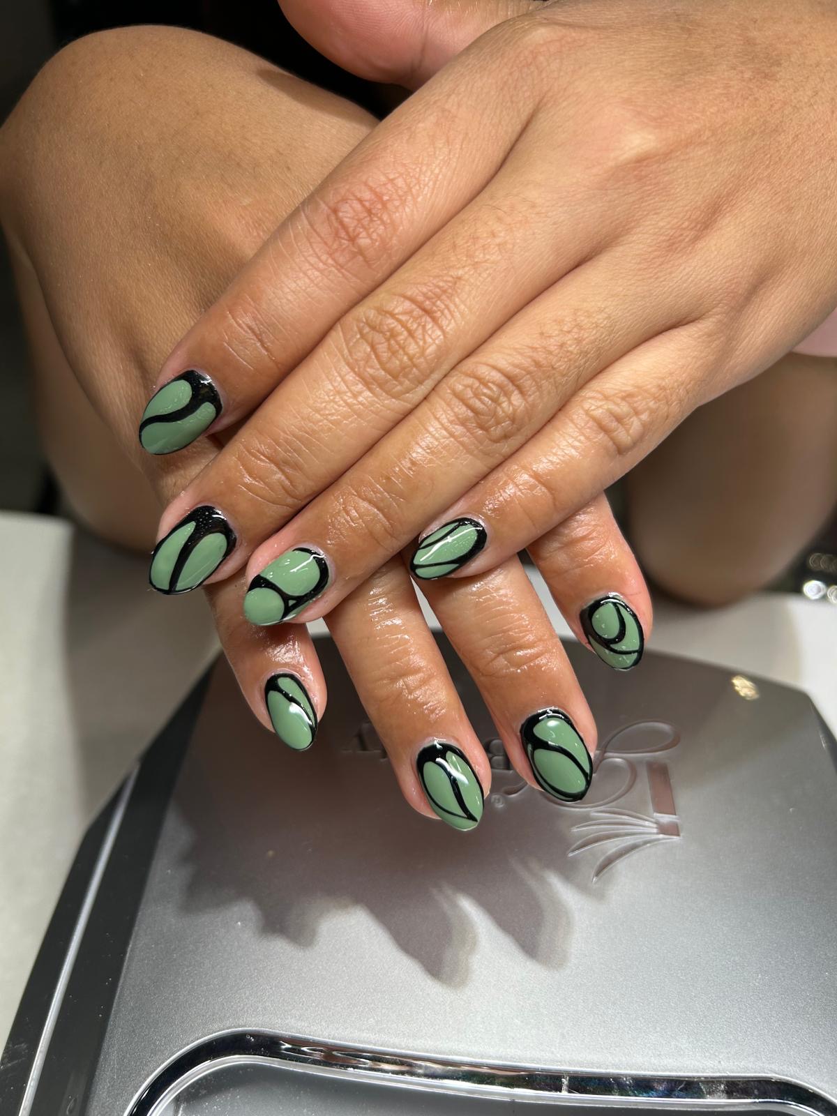 Sage green nails outlined in glossy black freehand line work